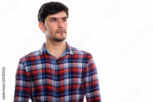 Studio shot of young Persian man thinking while looking up