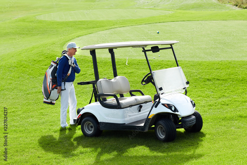 Aged man with golf bag standing by car while going to drive for outdoor leisure game Aged man with golf bag standing by car while going to drive for outdoor leisure game