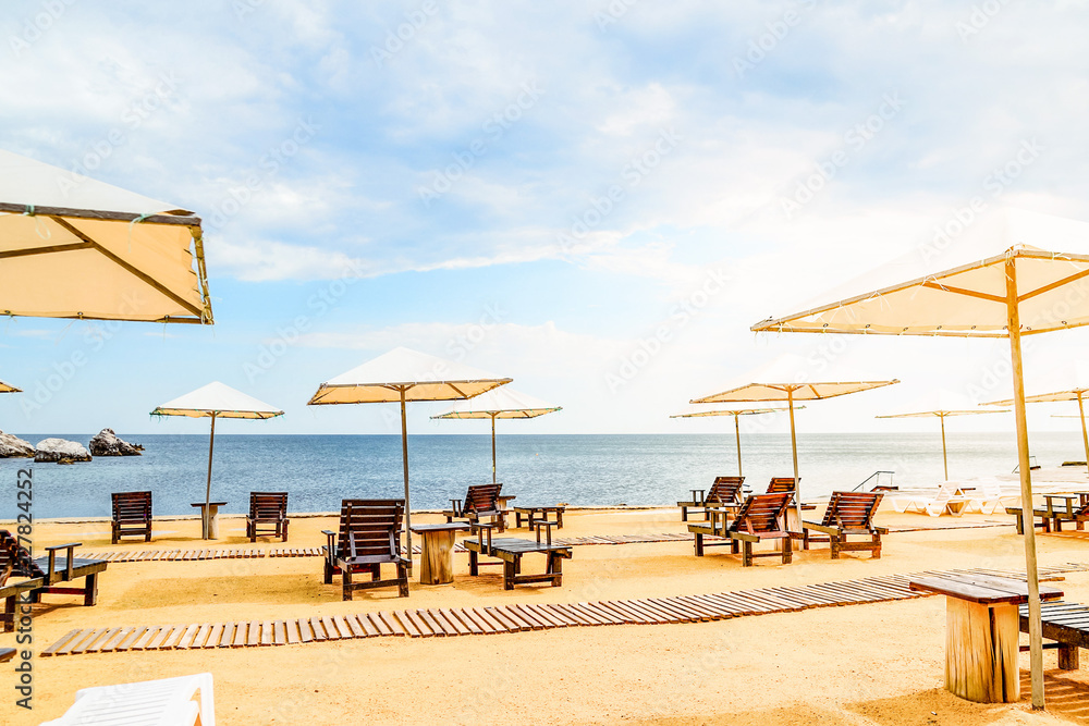 Beach umbrellas and sun beds on the sea coast