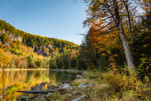 Fototapeta Naklejka Na Ścianę i Meble -  Mountain and colorful trees reflected in a pond on a beautiful autumn day