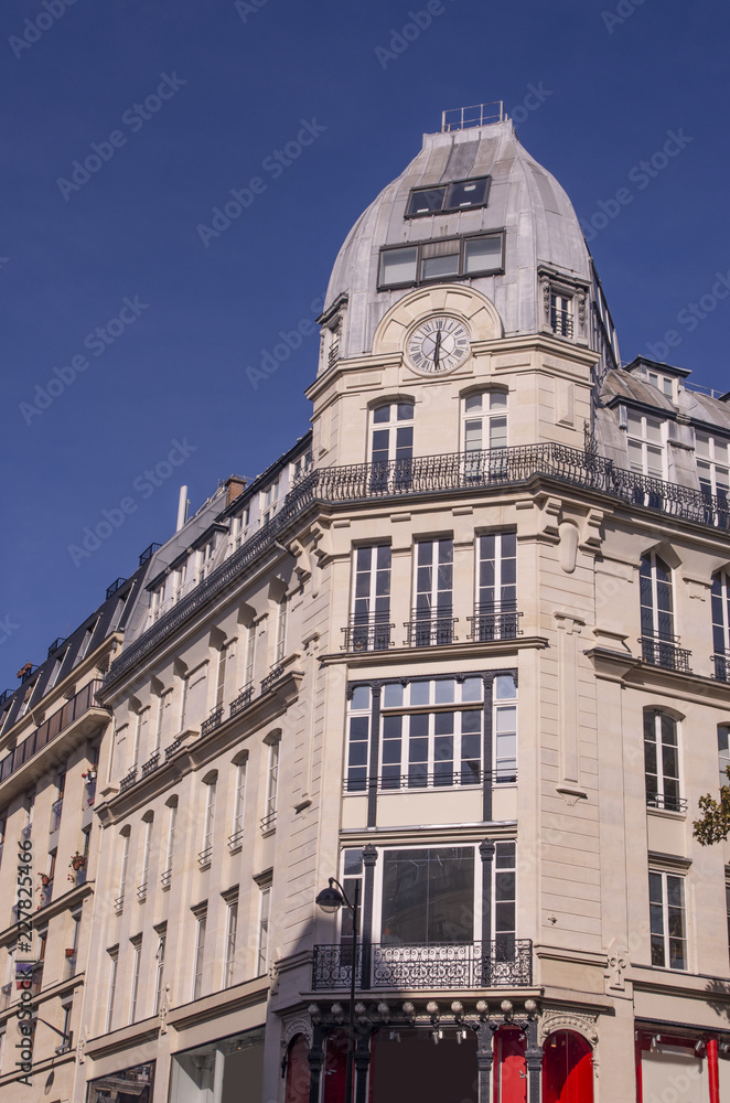 Roofs and building facades in Paris with a clock