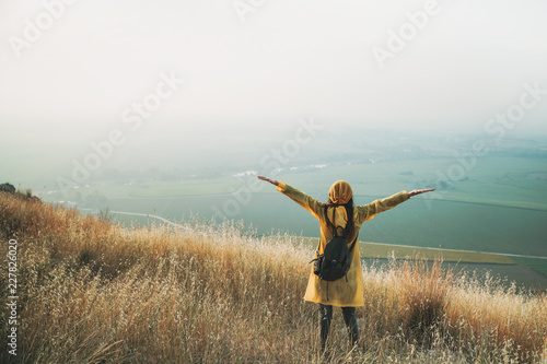 Cheering woman enjoy the beautiful view at mountain peak