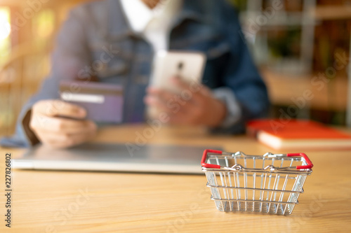 Woman is holding credit card and using smartphone. Online shopping concept.