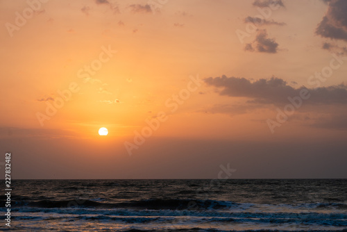 Setting sun disk on sky under sea