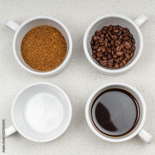 assortment of four white cups of coffee on a saucer grain, instant, brewed and an empty cup on the coffee table.