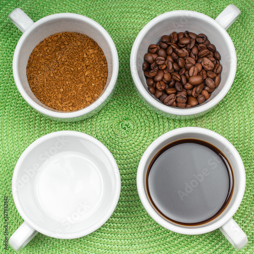assortment of four white cups of coffee on a saucer grain, instant, brewed and an empty cup on the green background