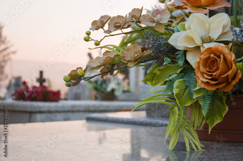 Floral decoration on the grave with a cementary in the background photo