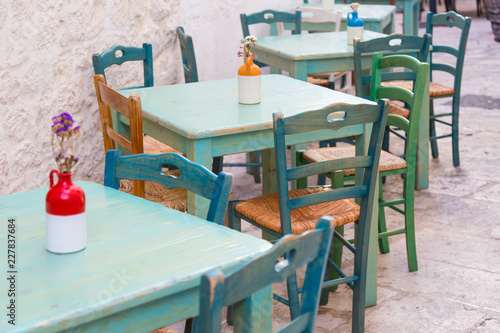 Green wooden outdoor tables and chairs of an italian restaurant