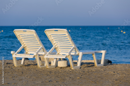 White  plastic sunbeds at golden hour on sandy beach of Zakynthos  Greece