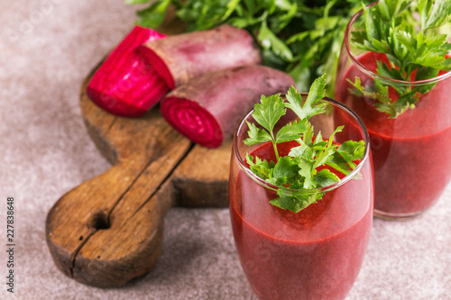 Bright beetroot smoothie in tumbler with fresh pieces of beet