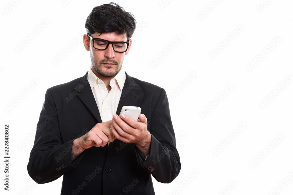 Studio shot of young Persian businessman using mobile phone Studio shot of young Persian businessman using mobile phone