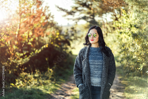 Pretty long hair bruntte girl walking in the autumn forest.