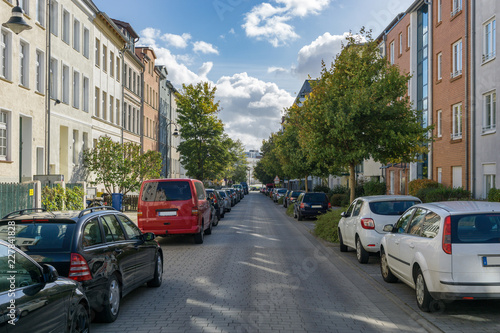 street view of an avenue in rostock - parked cars at the side