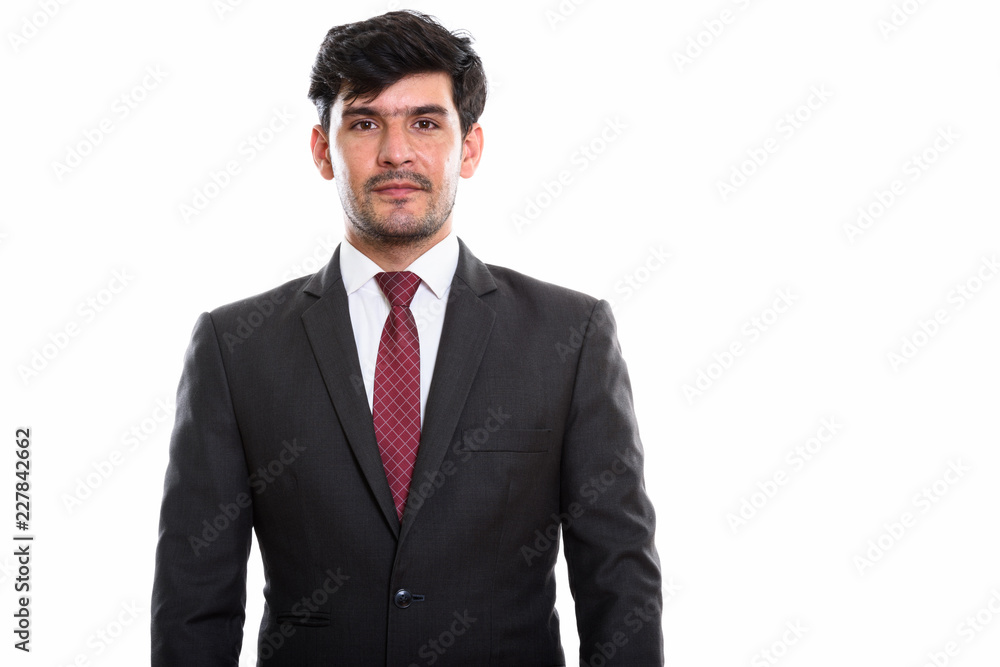 Studio shot of young Persian businessman standing Studio shot of young Persian businessman standing