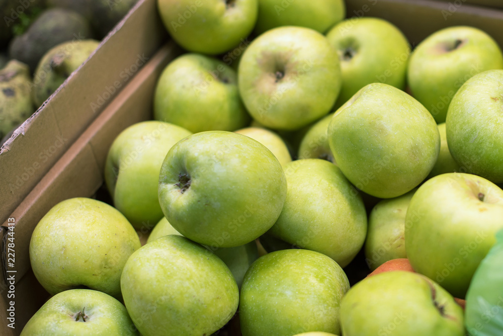 juicy green apples in a carton box are sold at the fruit shop. delicious ripe fruit. vegetable shop juicy green apples in a carton box are sold at the fruit shop. delicious ripe fruit. vegetable shop