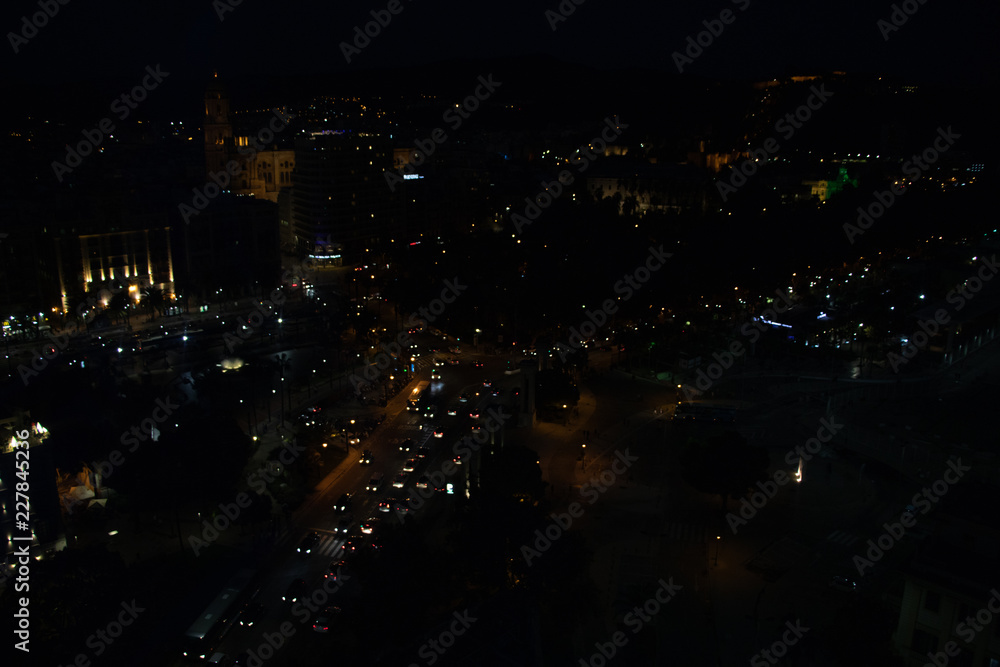 Aerial night view of a city and traffic of cars. Malaga, Spain