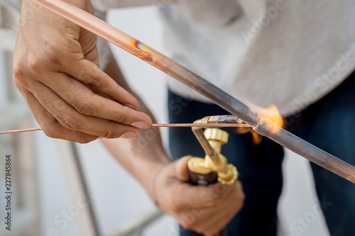 Welding of copper pipe of a methane gas pipeline or of a conditioning or water system. Welding soldering copper pipes. Gas Welding Pipe brass contractor air con mechanic Outdoors.