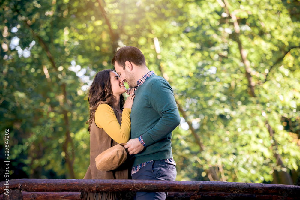 Fototapeta premium Beautiful love couple hugging and kissing in park