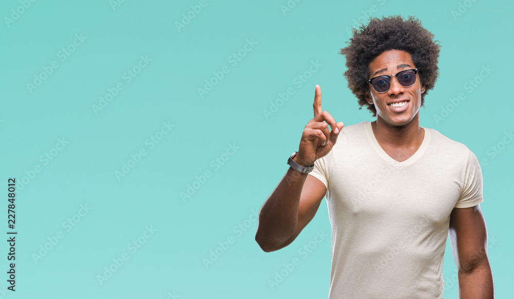 Afro american man wearing sunglasses over isolated background pointing finger up with successful idea. Exited and happy. Number one. Afro american man wearing sunglasses over isolated background pointing finger up with successful idea. Exited and happy. Number one.