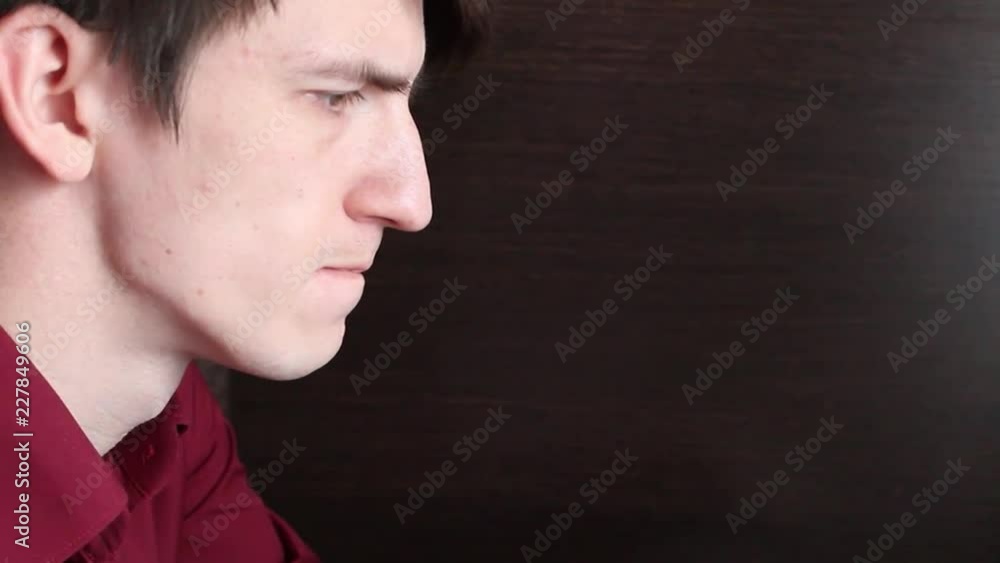 the guy pulls out and swallows the black pill from the white packaging, drinks water from the glass cup the guy pulls out and swallows the black pill from the white packaging, drinks water from the glass cup