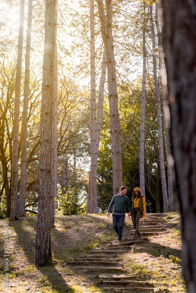 Beautiful smiling love couple walking in colorful autumn forest park Beautiful smiling love couple walking in colorful autumn forest park