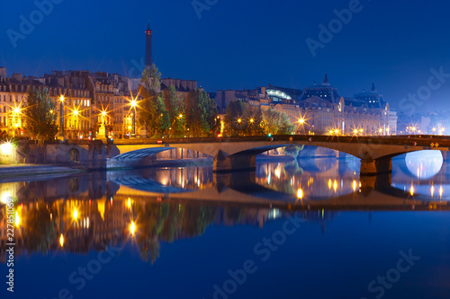 Beautiful view of Seine, Eiffel tower and bridge Pont Royal during morning blue hour in Paris, France