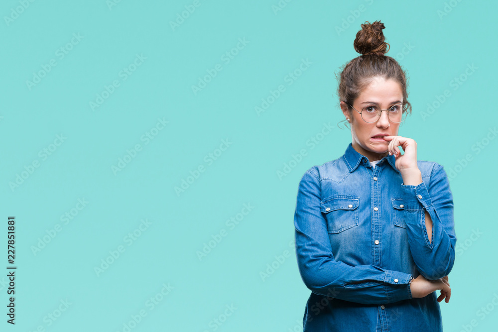 Beautiful young brunette curly hair girl wearing glasses over isolated background looking stressed and nervous with hands on mouth biting nails. Anxiety problem. Beautiful young brunette curly hair girl wearing glasses over isolated background looking stressed and nervous with hands on mouth biting nails. Anxiety problem.
