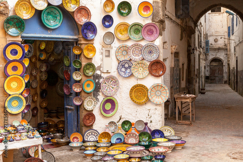 Morocco Essaouira colorful pottery dishes on display outside a shop located in a maze of pedestrian shopping alleyways photo