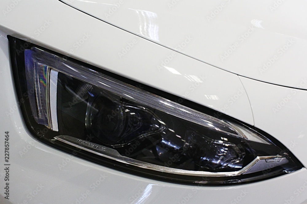 Sleek LED head light of modern korean SUV automobile, white chassis colour