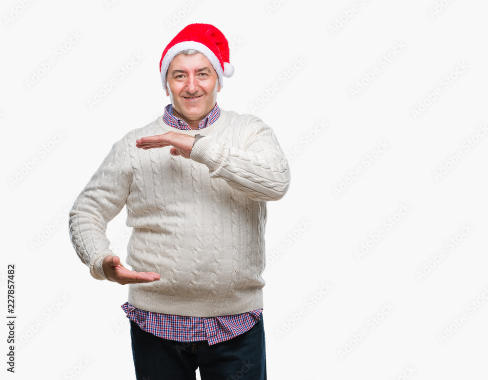 Handsome senior man wearing christmas hat over isolated background gesturing with hands showing big and large size sign, measure symbol. Smiling looking at the camera. Measuring concept. Handsome senior man wearing christmas hat over isolated background gesturing with hands showing big and large size sign, measure symbol. Smiling looking at the camera. Measuring concept.