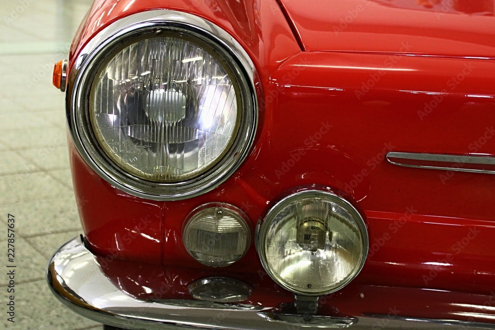 Part of front mask and round headlights of small vintage italian coupe automobile, production year around 1965
