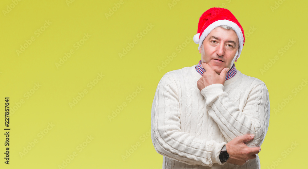 Handsome senior man wearing christmas hat over isolated background looking confident at the camera with smile with crossed arms and hand raised on chin. Thinking positive. Handsome senior man wearing christmas hat over isolated background looking confident at the camera with smile with crossed arms and hand raised on chin. Thinking positive.