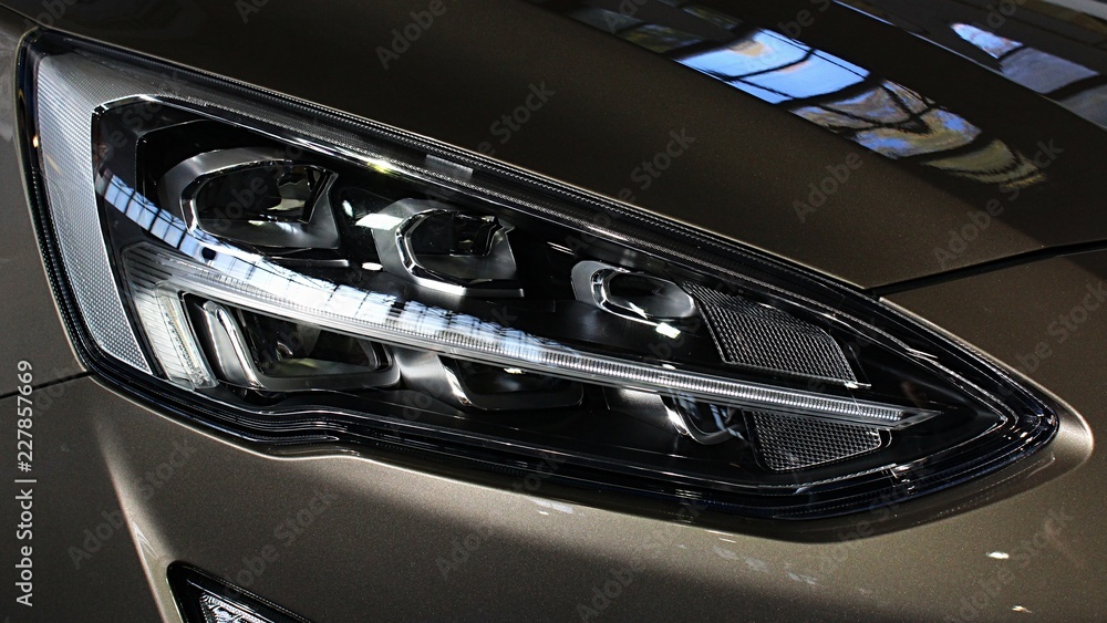 Sleek LED headlight of modern american compact SUV car. 