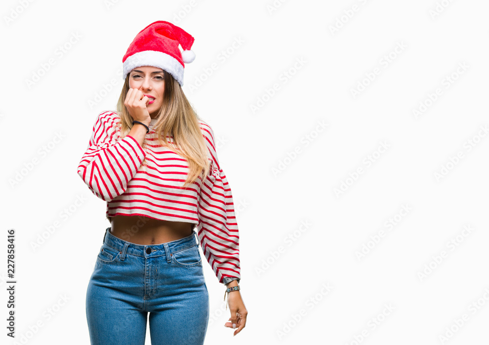 Young beautiful woman wearing christmas hat over isolated background looking stressed and nervous with hands on mouth biting nails. Anxiety problem. Young beautiful woman wearing christmas hat over isolated background looking stressed and nervous with hands on mouth biting nails. Anxiety problem.
