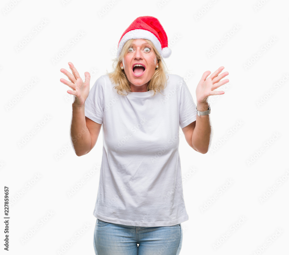 Middle age blonde woman wearing christmas hat over isolated background celebrating crazy and amazed for success with arms raised and open eyes screaming excited. Winner concept Middle age blonde woman wearing christmas hat over isolated background celebrating crazy and amazed for success with arms raised and open eyes screaming excited. Winner concept