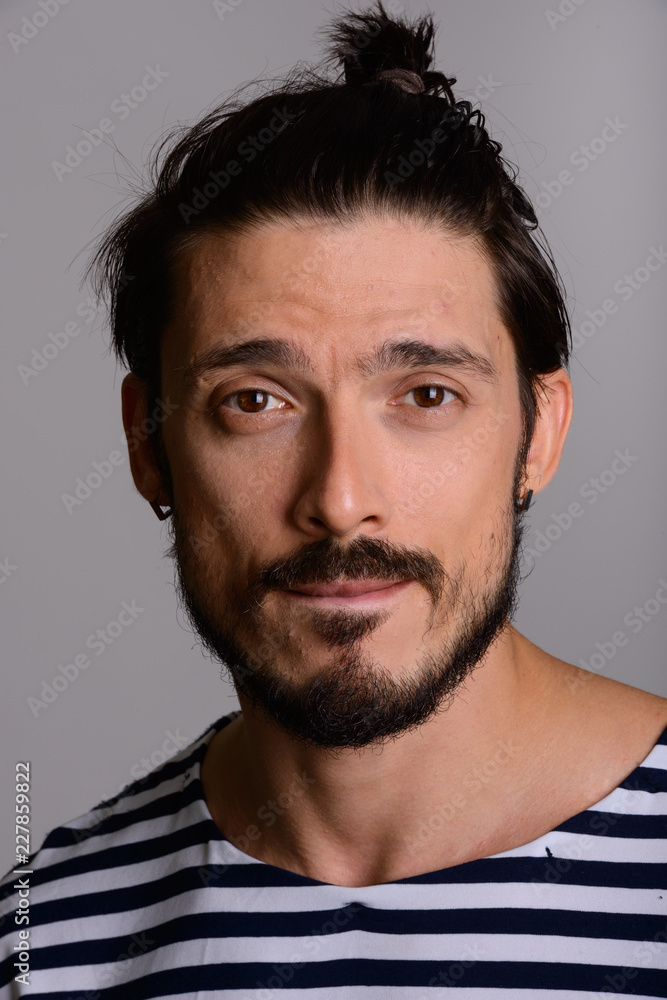 Face of handsome man hair tied back and biting lip Stock Photo | Adobe Stock