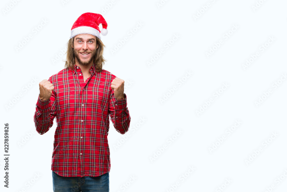 Young handsome man with long hair wearing santa claus hat over isolated background celebrating surprised and amazed for success with arms raised and open eyes. Winner concept. Young handsome man with long hair wearing santa claus hat over isolated background celebrating surprised and amazed for success with arms raised and open eyes. Winner concept.