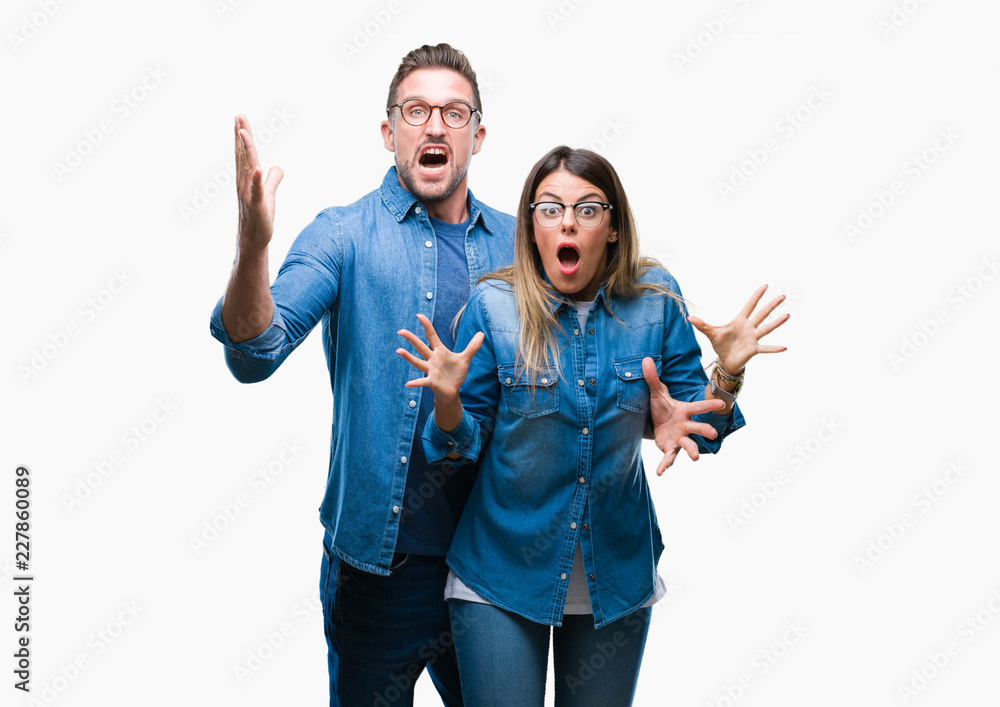 Fototapeta premium Young couple in love wearing glasses over isolated background celebrating crazy and amazed for success with arms raised and open eyes screaming excited. Winner concept