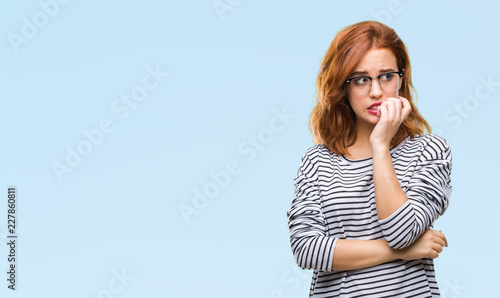 Foto Young beautiful woman over isolated background wearing glasses looking stressed and nervous with hands on mouth biting nails