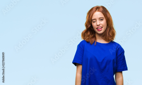 Young beautiful woman over isolated background winking looking at the camera with sexy expression, cheerful and happy face.