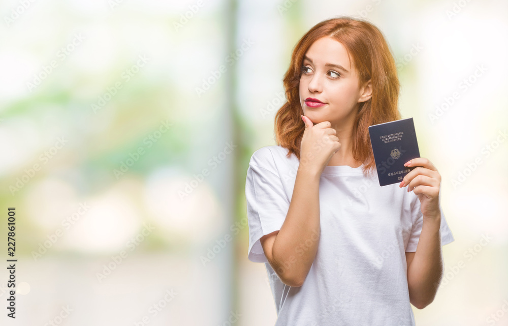 Young beautiful woman holding passport of germany over isolated background serious face thinking about question, very confused idea Young beautiful woman holding passport of germany over isolated background serious face thinking about question, very confused idea