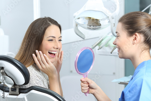 Fototapeta Naklejka Na Ścianę i Meble -  Happy dentist patient checking whitening results