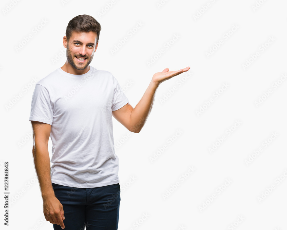 Young handsome man over isolated background smiling cheerful presenting and pointing with palm of hand looking at the camera. Young handsome man over isolated background smiling cheerful presenting and pointing with palm of hand looking at the camera.