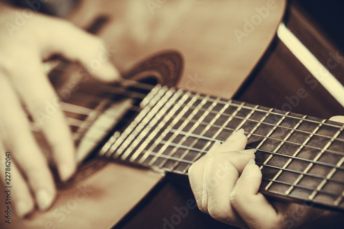 Closeup of man playing acoustic guitar photo