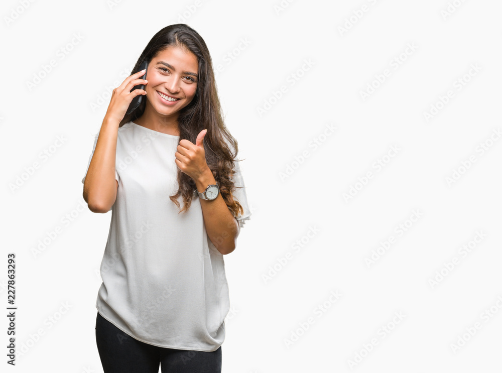 Young beautiful arab woman talking on the phone over isolated background happy with big smile doing ok sign, thumb up with fingers, excellent sign Young beautiful arab woman talking on the phone over isolated background happy with big smile doing ok sign, thumb up with fingers, excellent sign