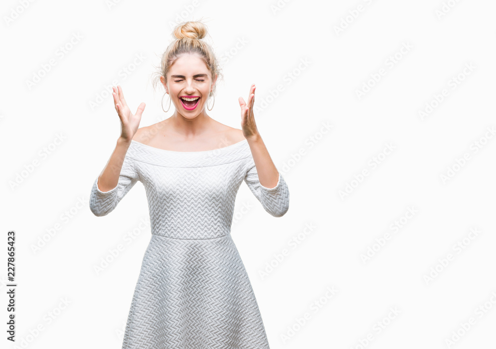 Young beautiful blonde and blue eyes woman over isolated background celebrating mad and crazy for success with arms raised and closed eyes screaming excited. Winner concept Young beautiful blonde and blue eyes woman over isolated background celebrating mad and crazy for success with arms raised and closed eyes screaming excited. Winner concept