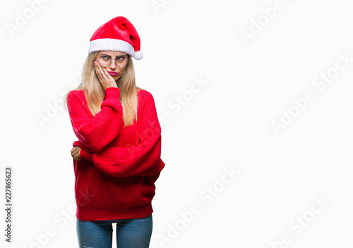 Young beautiful blonde woman wearing christmas hat over isolated background thinking looking tired and bored with depression problems with crossed arms.