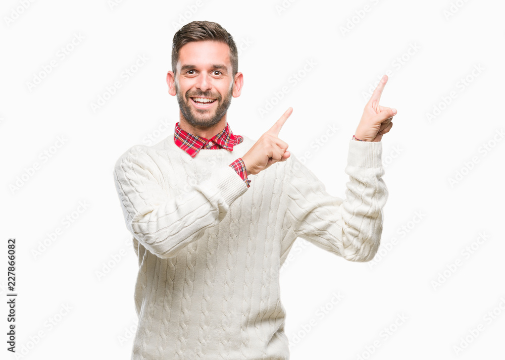 Young handsome man wearing winter sweater over isolated background smiling and looking at the camera pointing with two hands and fingers to the side. Young handsome man wearing winter sweater over isolated background smiling and looking at the camera pointing with two hands and fingers to the side.