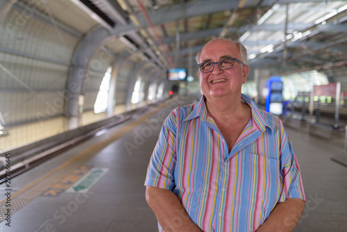 Overweight senior tourist man exploring around the city of Bangk photo