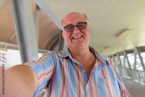 Overweight senior tourist man exploring around the city of Bangk photo